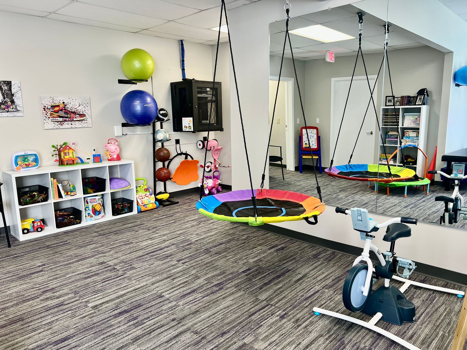 A room with a swing and a bike in it.