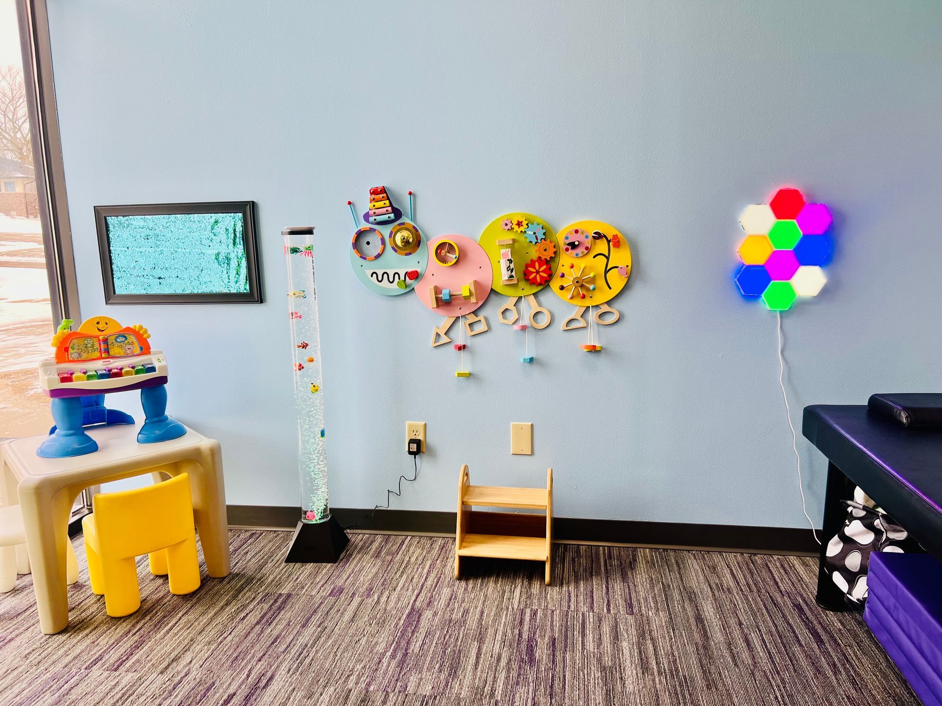 A room with a table , chairs , and balloons on the wall.