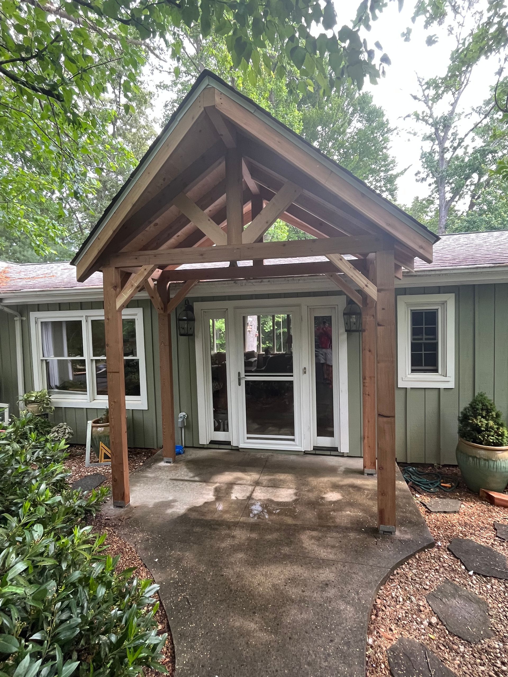 A house with a wooden porch and a walkway leading to it.
