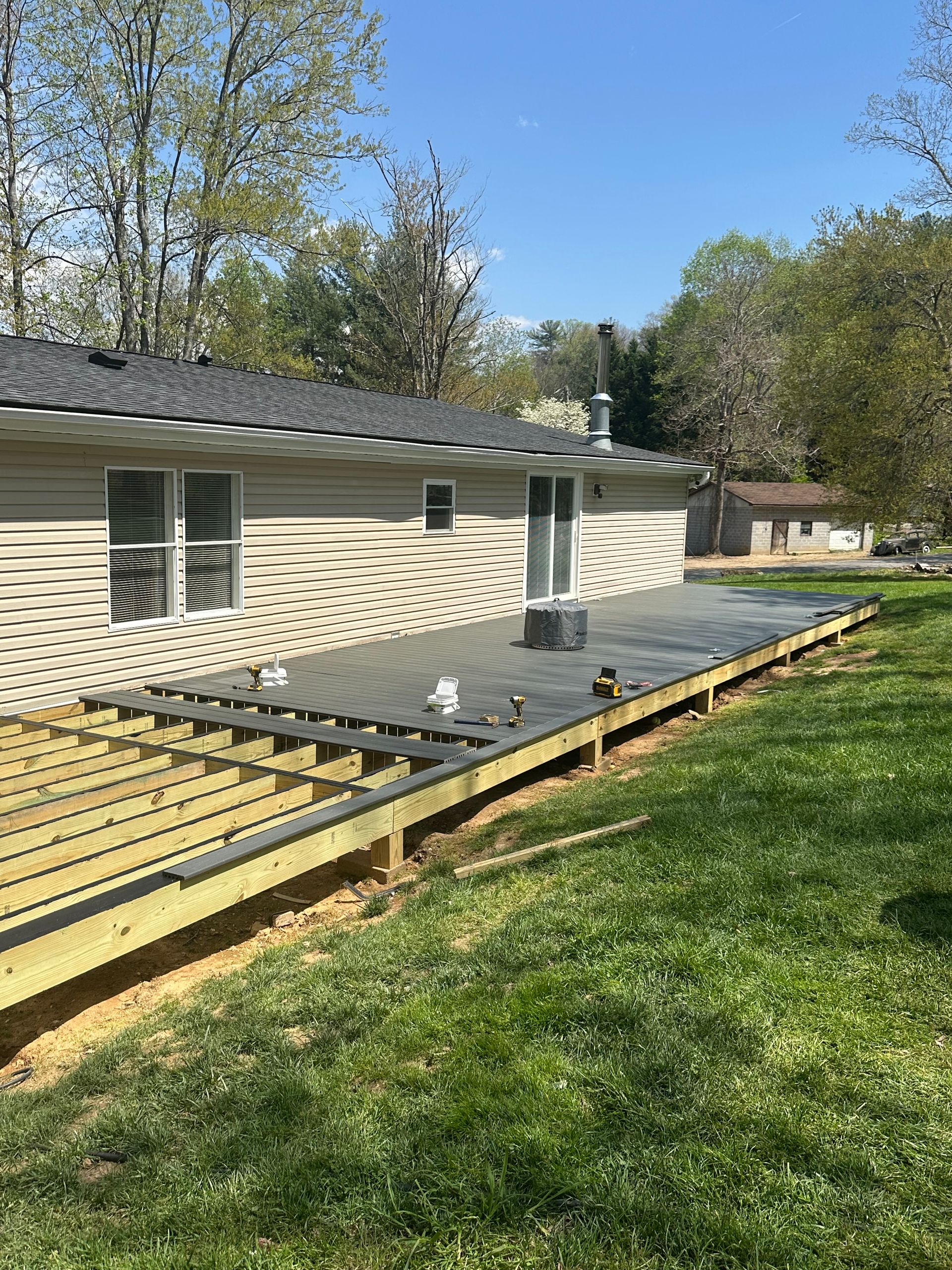 A wooden deck is being built in front of a house.