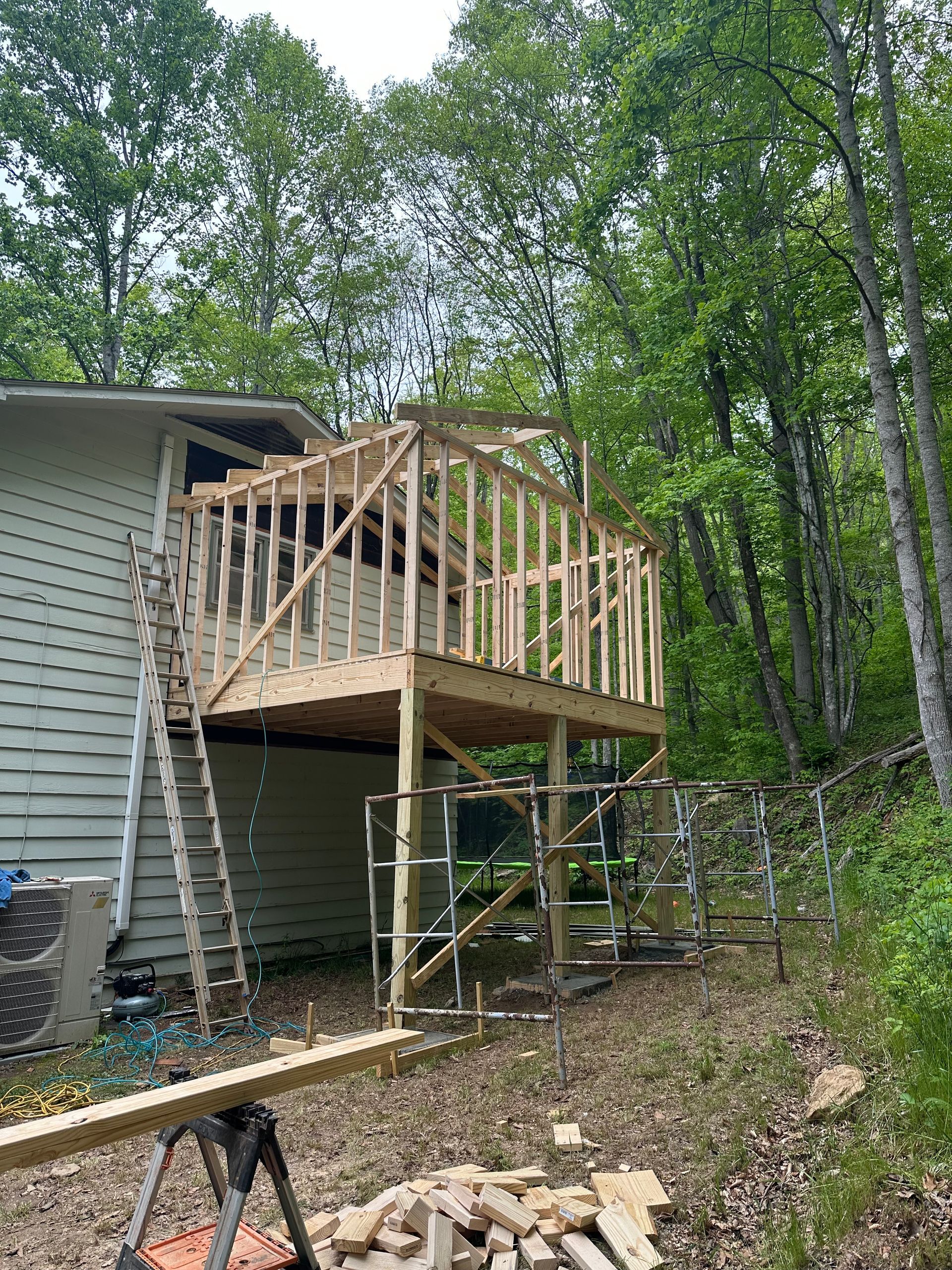 A wooden deck is being built on top of a house.