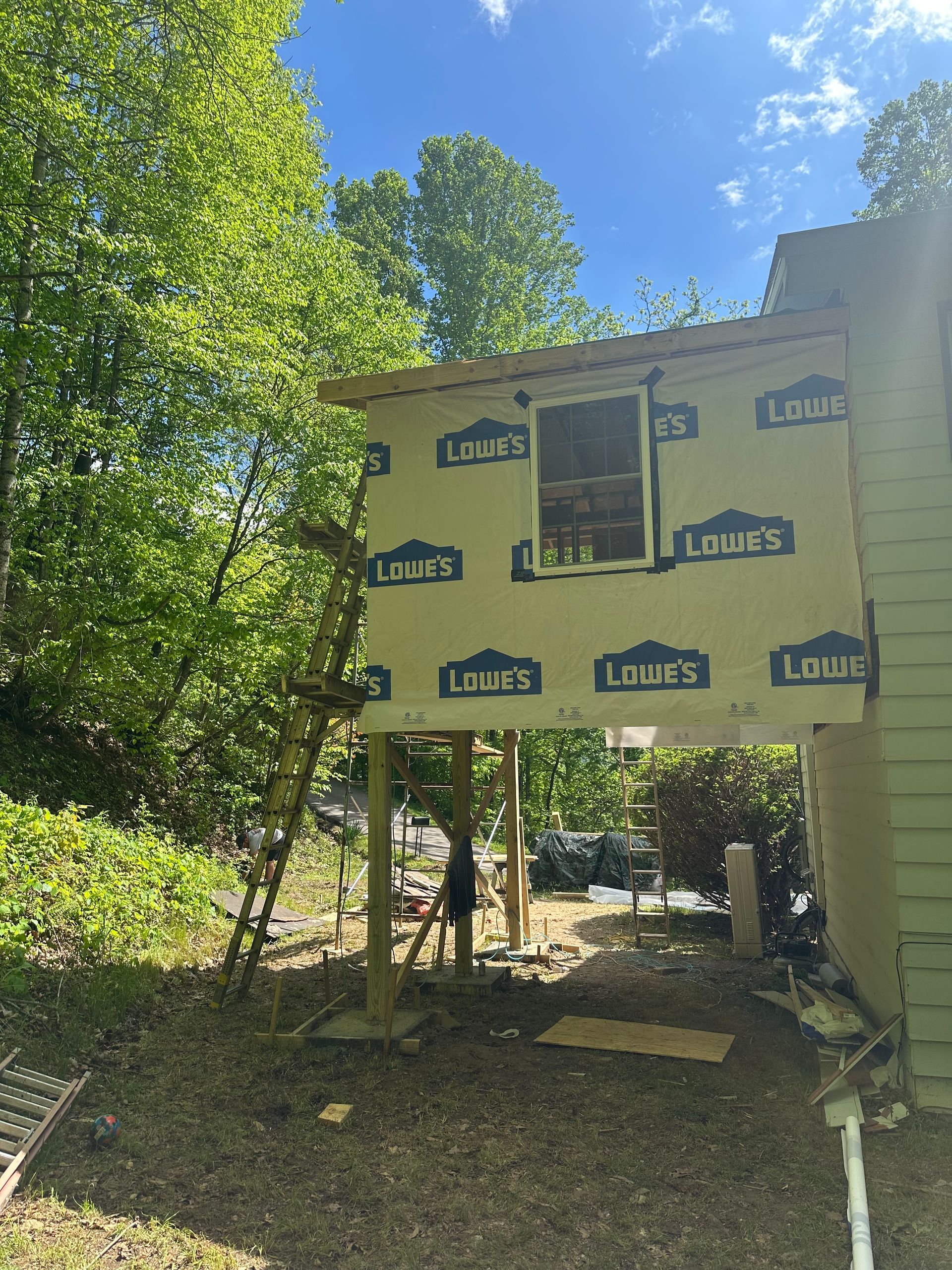 A house is being built on stilts in the backyard.