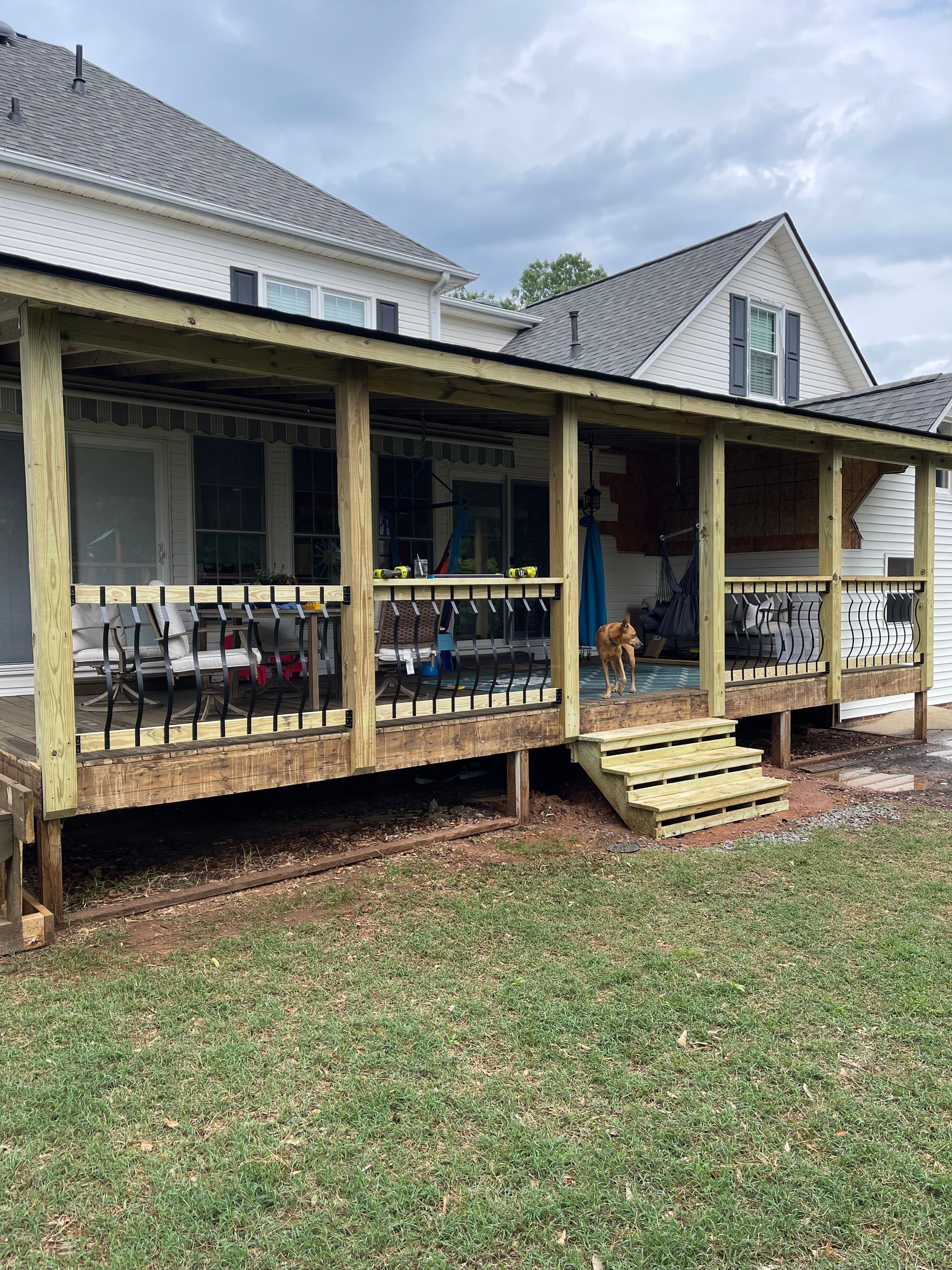 A wooden porch is being built on the side of a house.