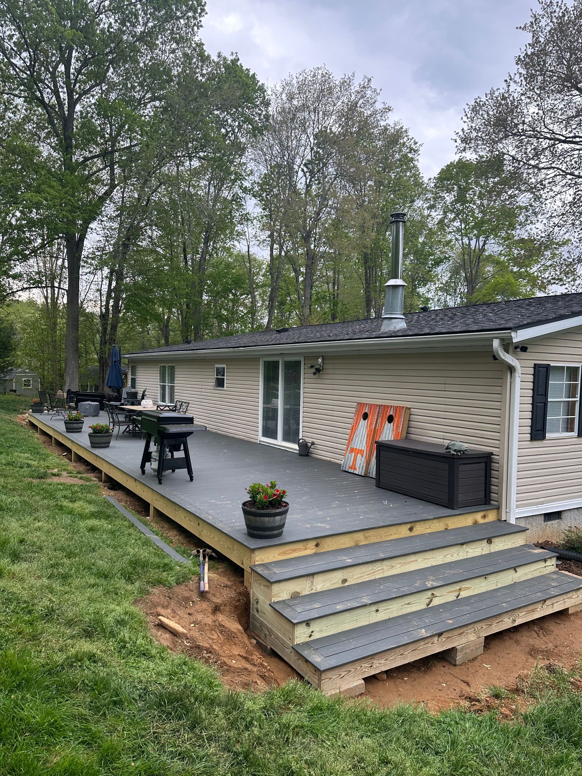 A mobile home with a large deck in front of it.