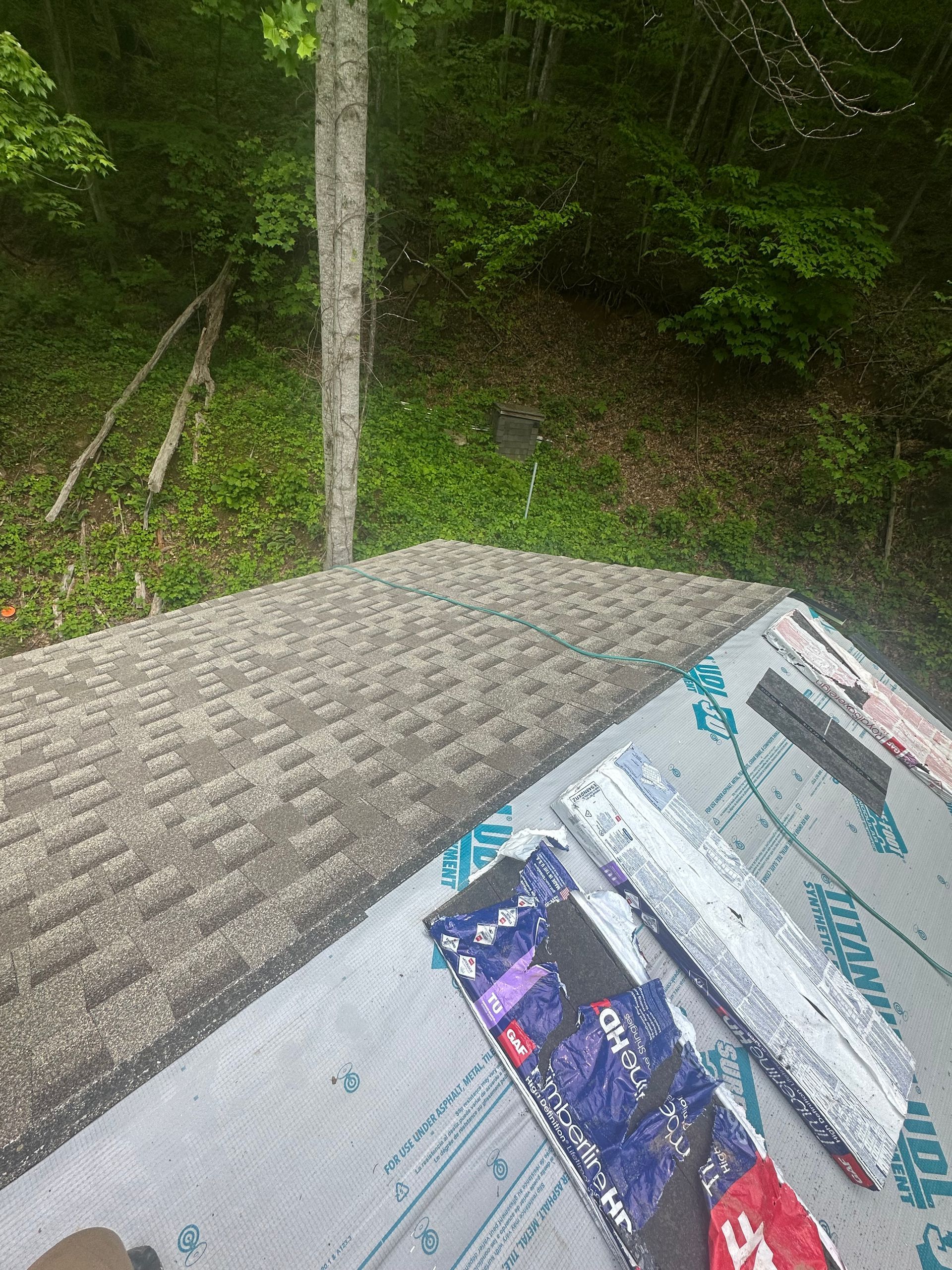 A roof with a lot of shingles and a lot of tools on it.