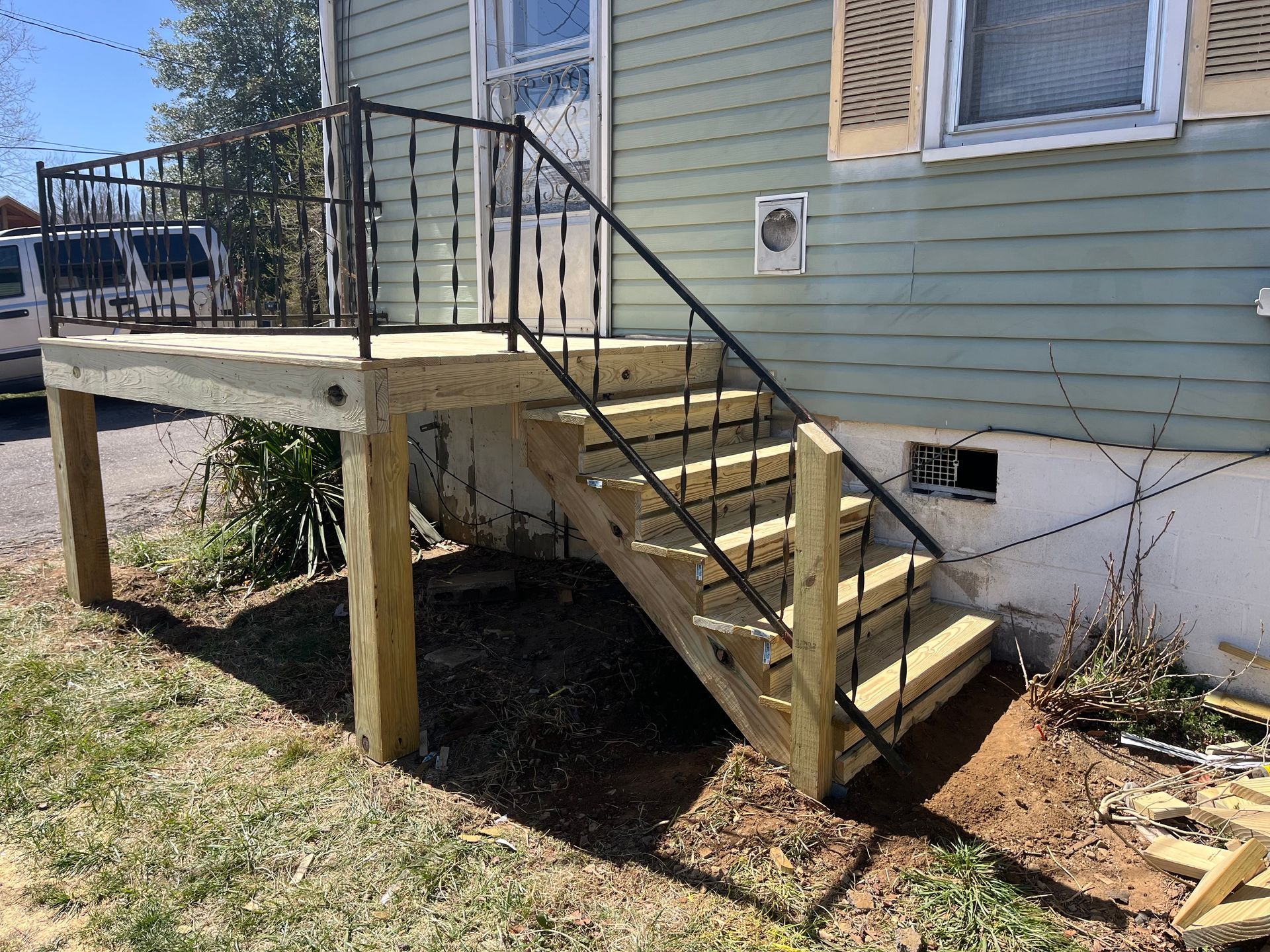 A wooden deck with stairs leading up to a house.