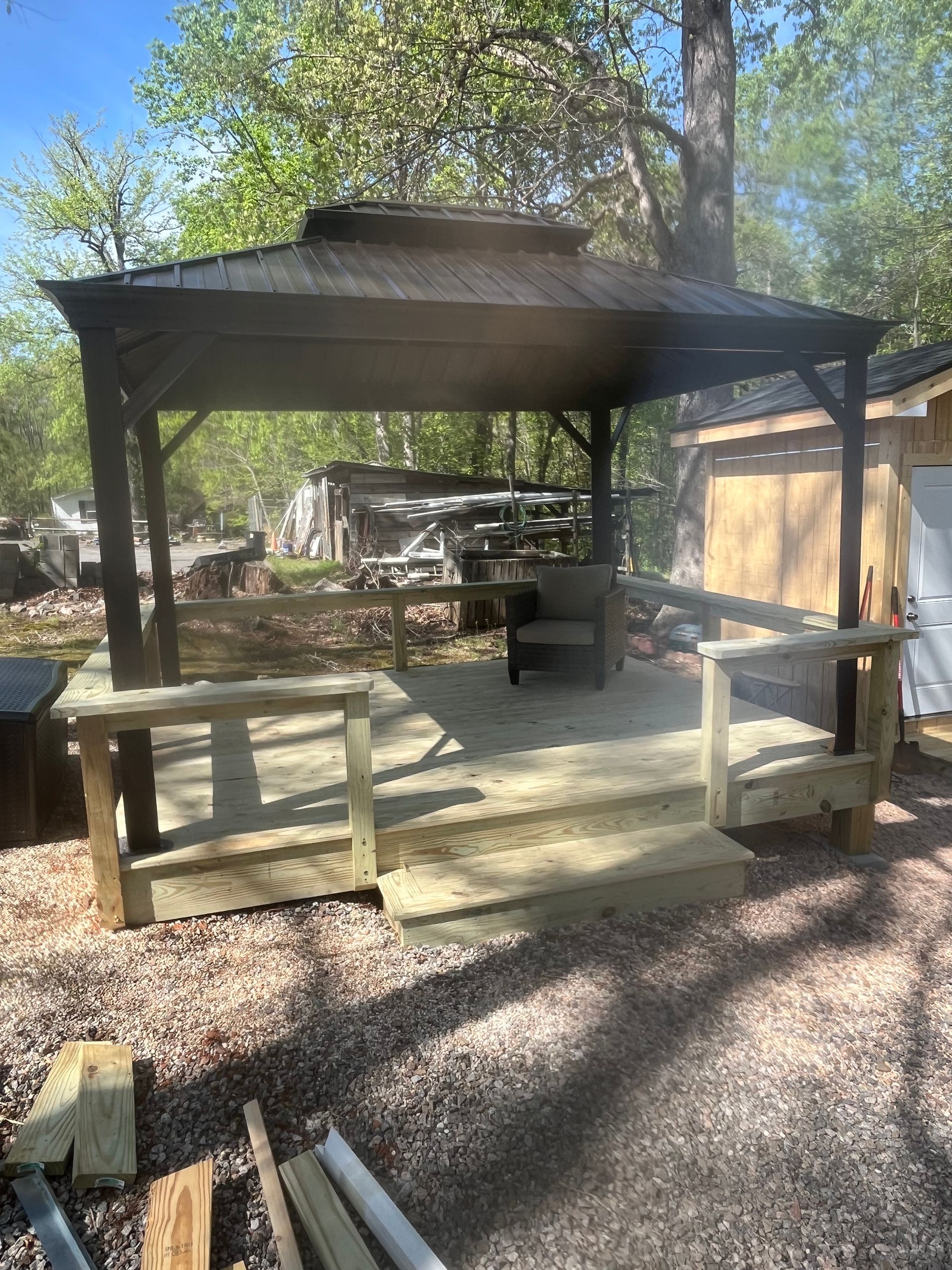 A gazebo is sitting on top of a wooden deck.