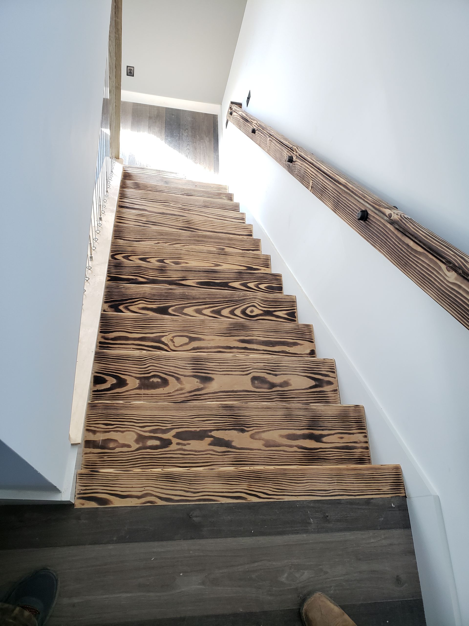 The stairs are made of wood and have a wooden railing