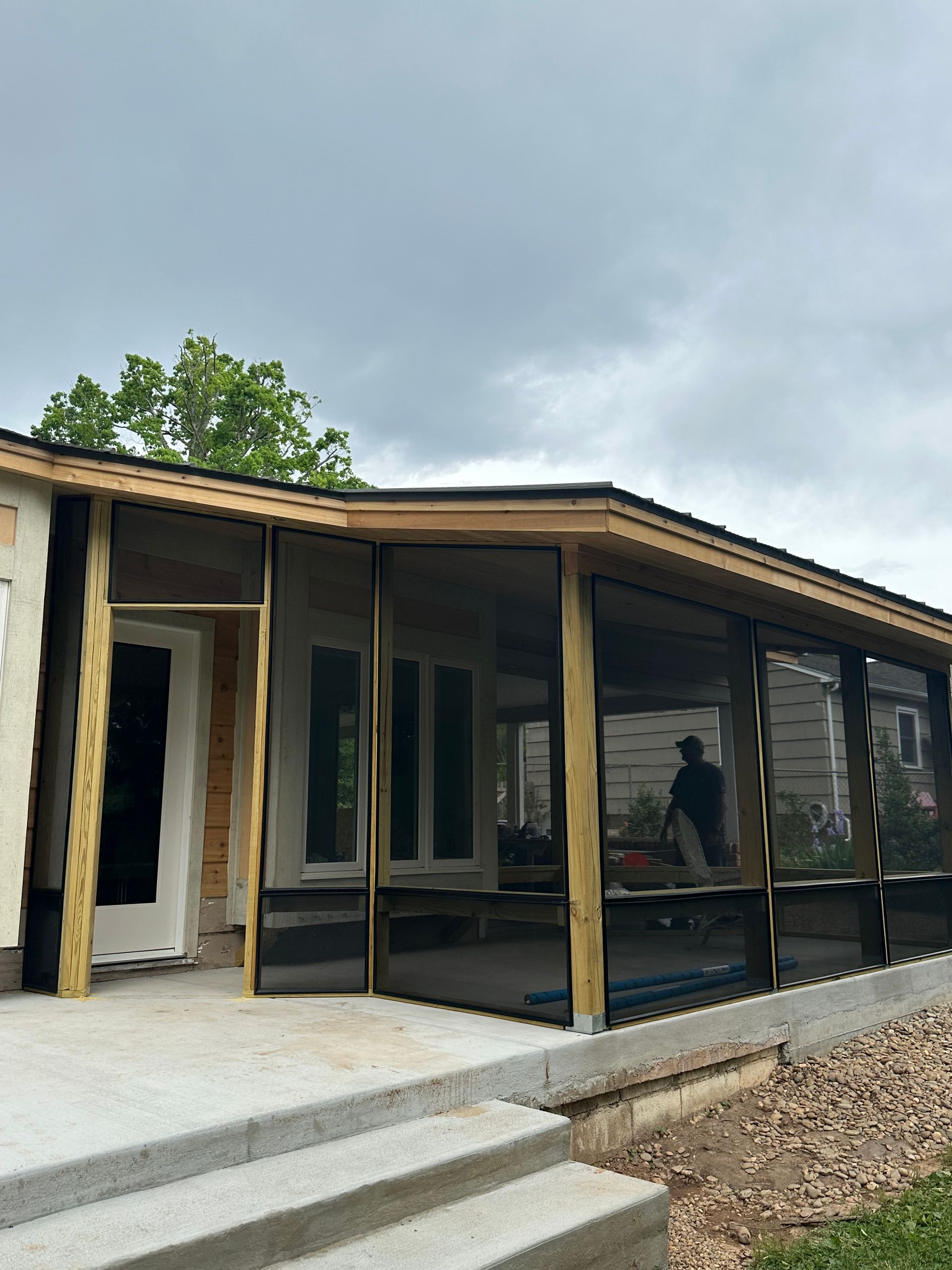 A house with a screened in porch and stairs.