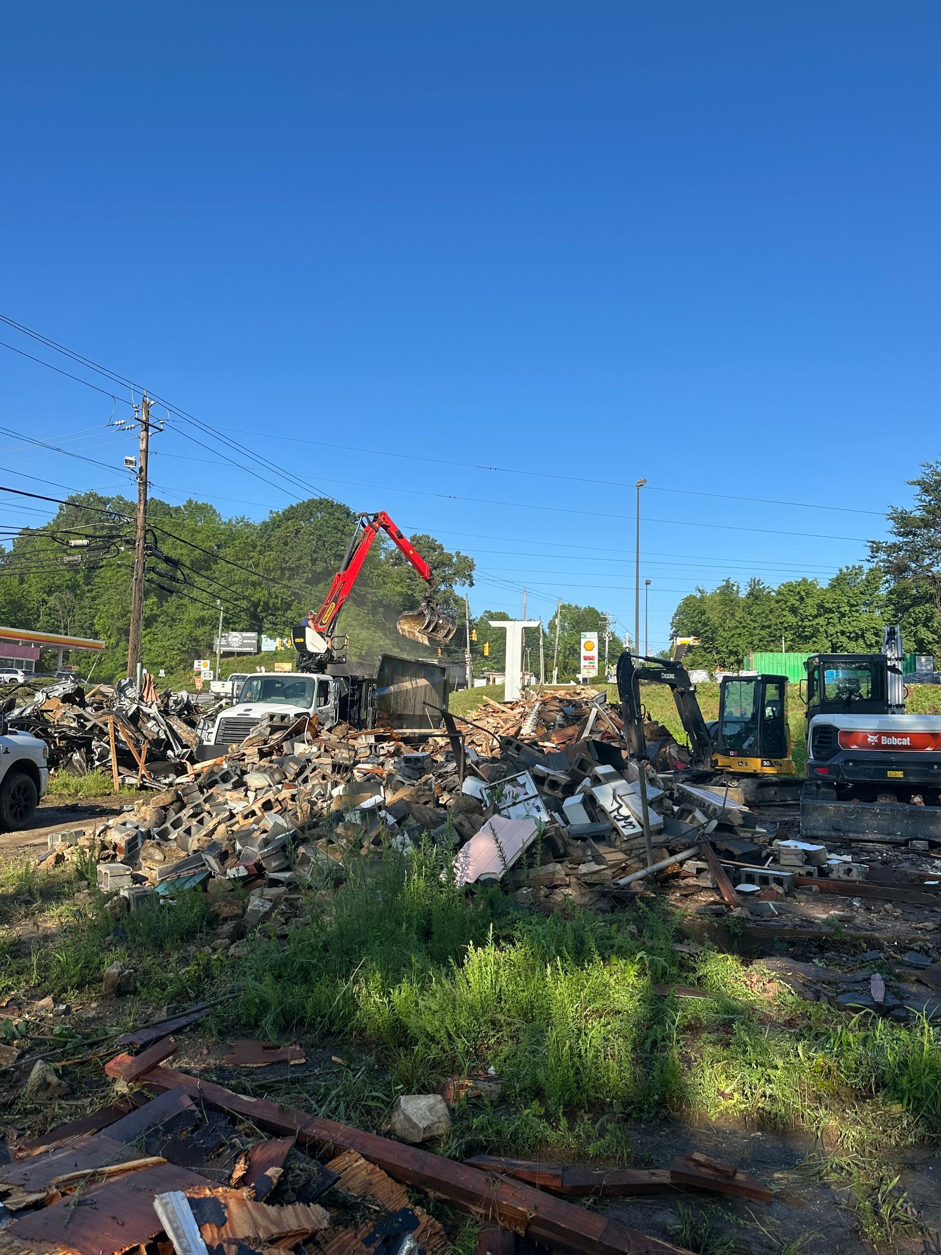 A large pile of rubble is being demolished by a bulldozer.