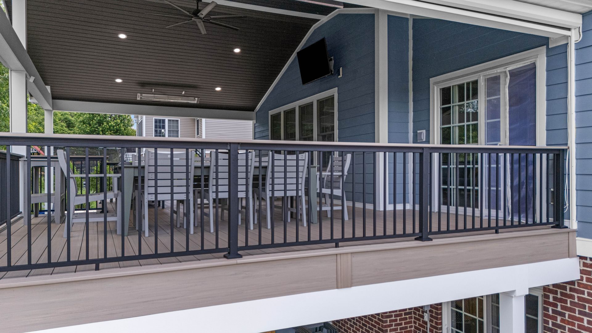 Covered balcony with gray railing and blue siding in an apartment complex