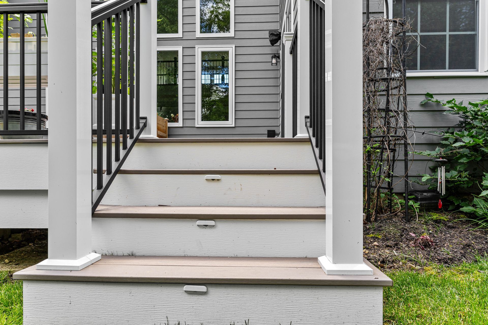 Front porch ramp with black railings leading to a gray house entrance