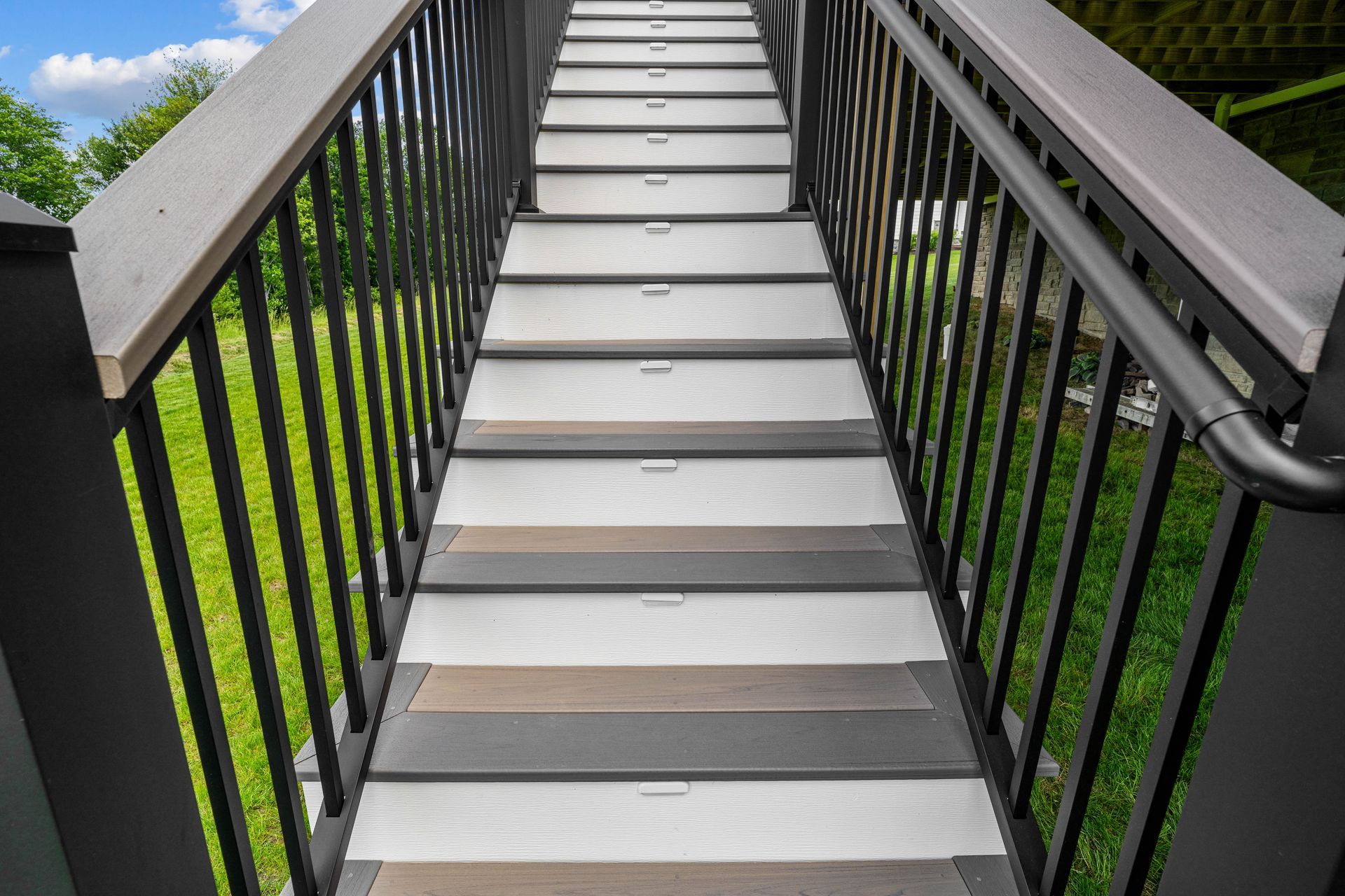 Stairway with black railings and gray steps leading upward outdoors