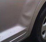 A close up of a car door and wheel.
