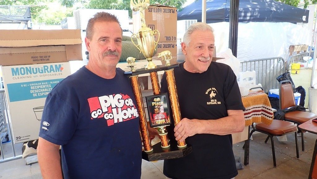 two men are standing next to each other holding a trophy