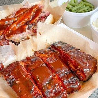 a tray of ribs and green beans on a table