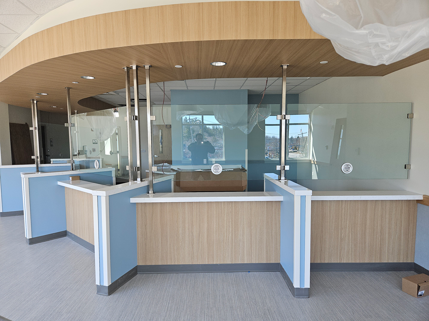 Empty modern reception desk with glass partitions and wood-paneled counters