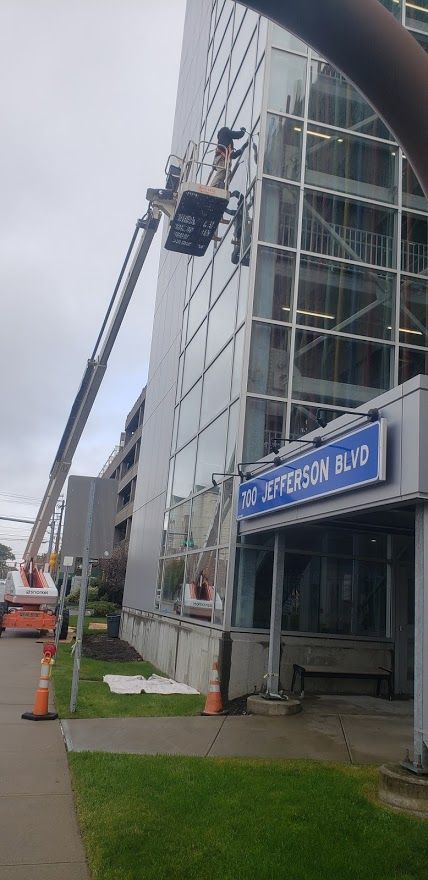 Workers in a lift working on a modern building at 345 Jefferson Blvd.
