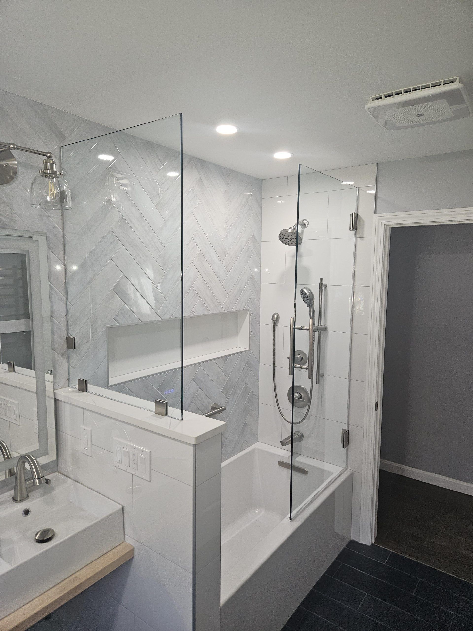 Modern bathroom with a bathtub, shower, glass enclosure, and white tile walls.