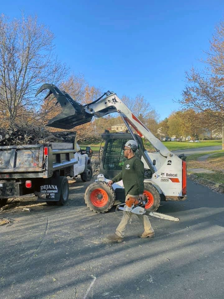 A man is walking in front of a bobcat truck.