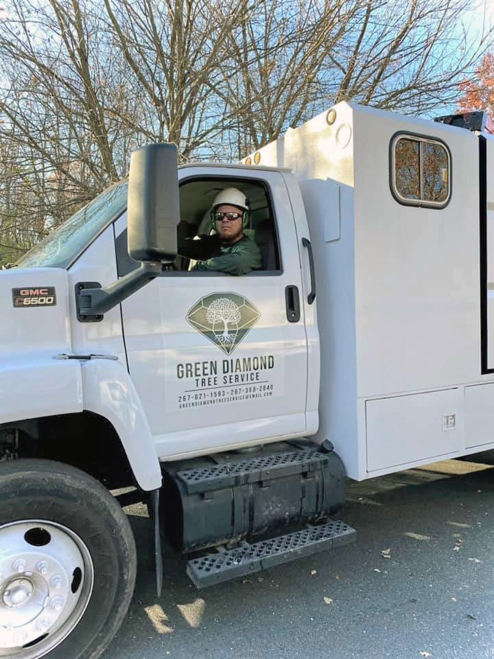 A man is sitting in the driver 's seat of a white truck.