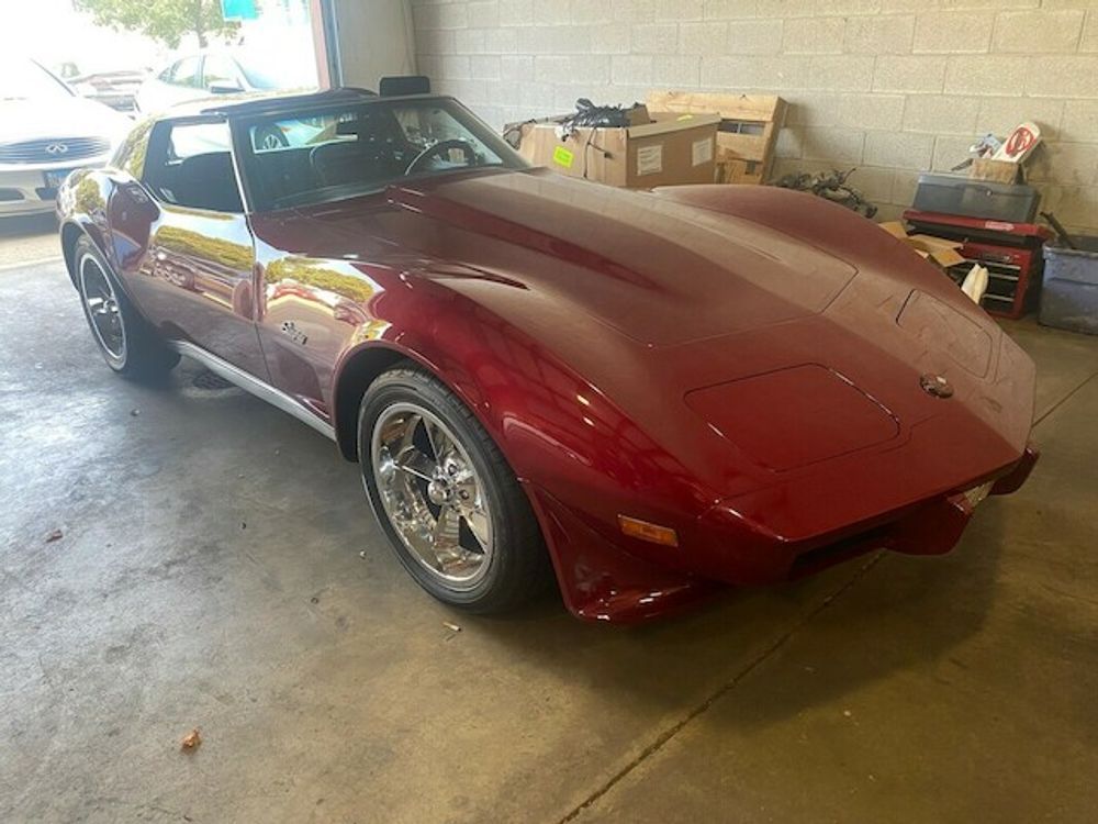 Red classic Corvette in a garage.