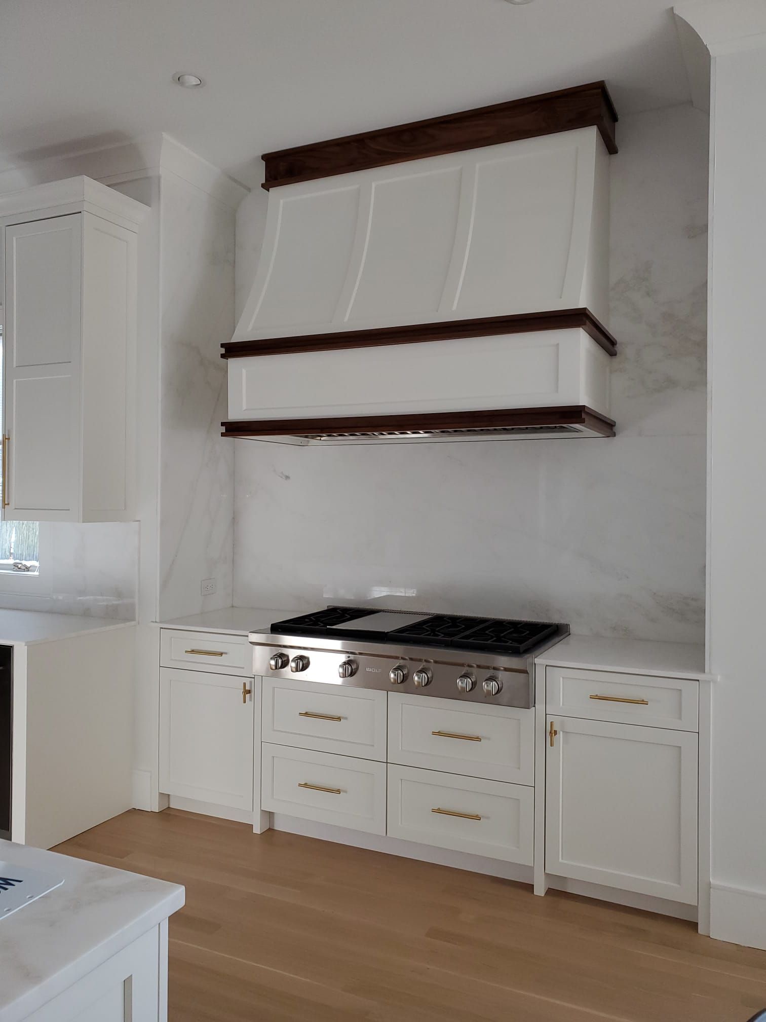 A kitchen with white cabinets and a stove top oven.