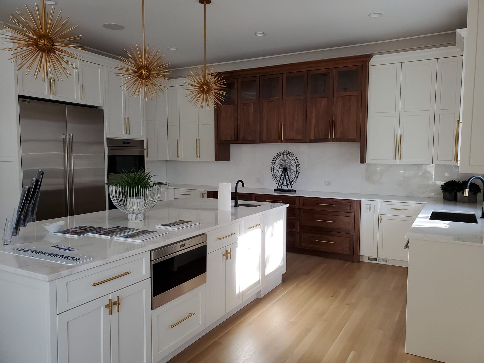 A kitchen with white cabinets, wooden cabinets, stainless steel appliances, and a large island.