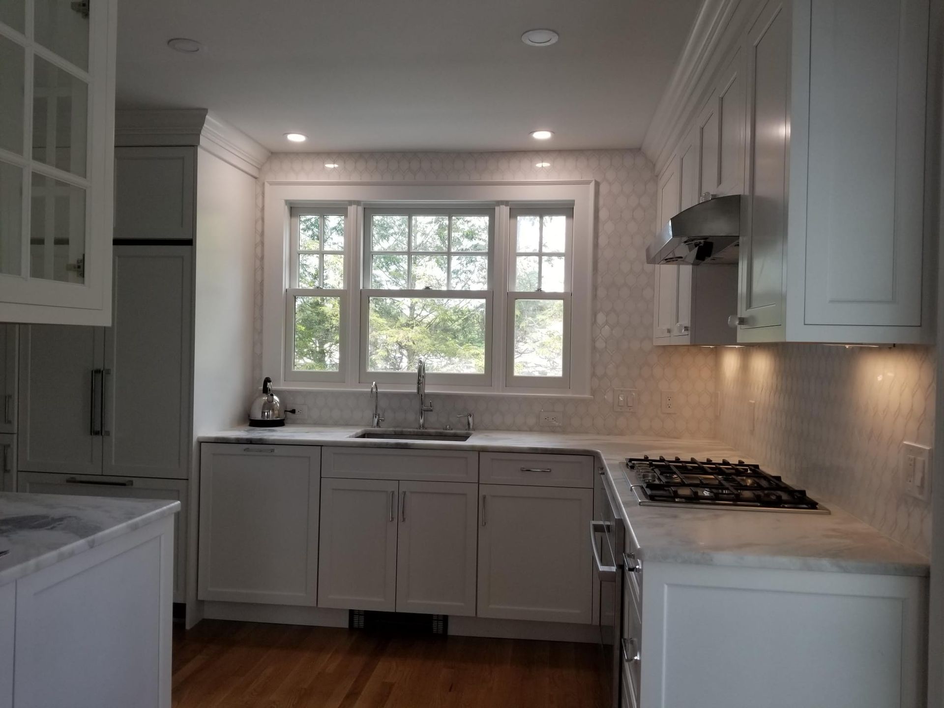 A kitchen with white cabinets and a stove top oven