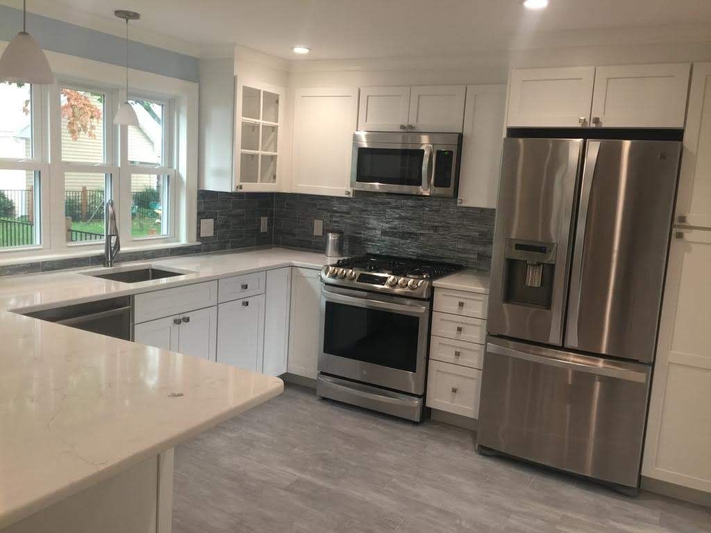 A kitchen with stainless steel appliances and white cabinets.