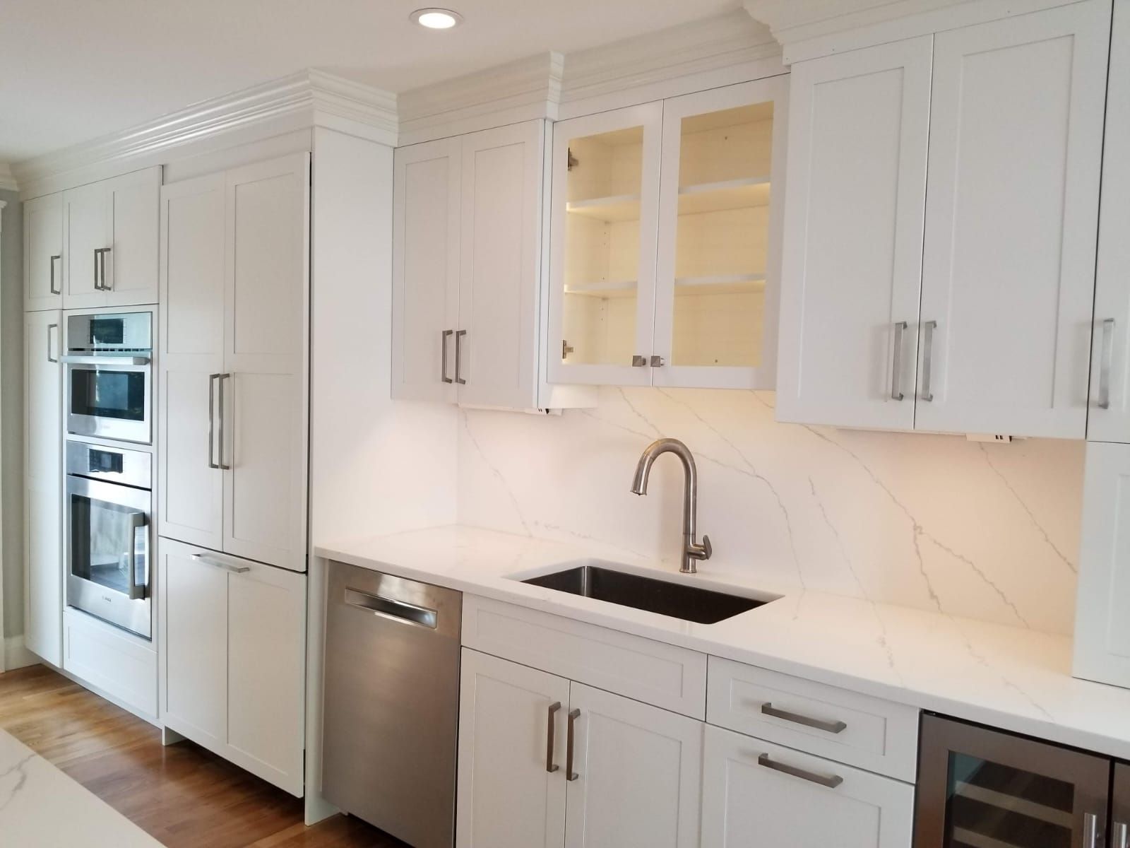 A kitchen with white cabinets and stainless steel appliances