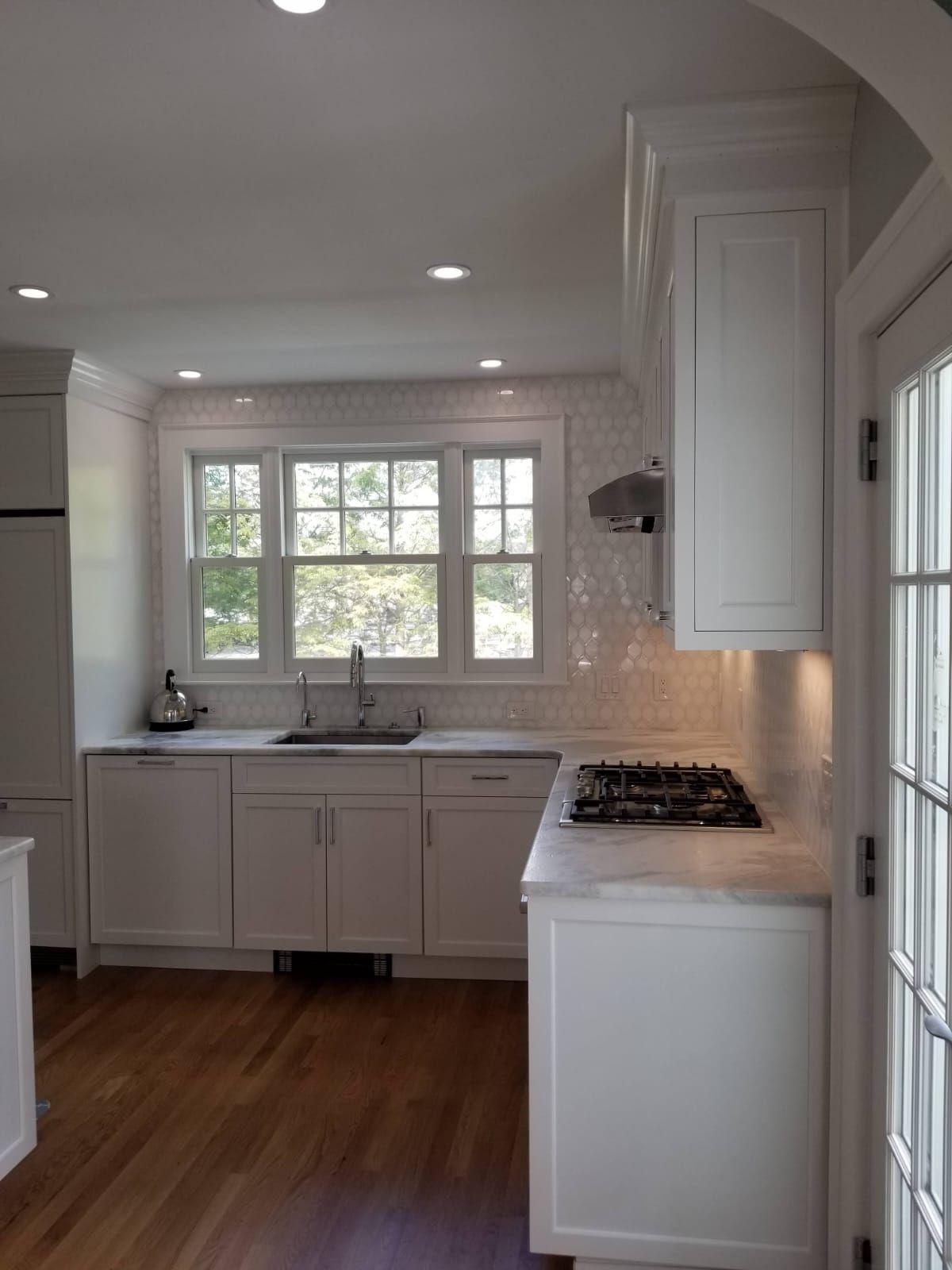 A kitchen with white cabinets and a stove top oven
