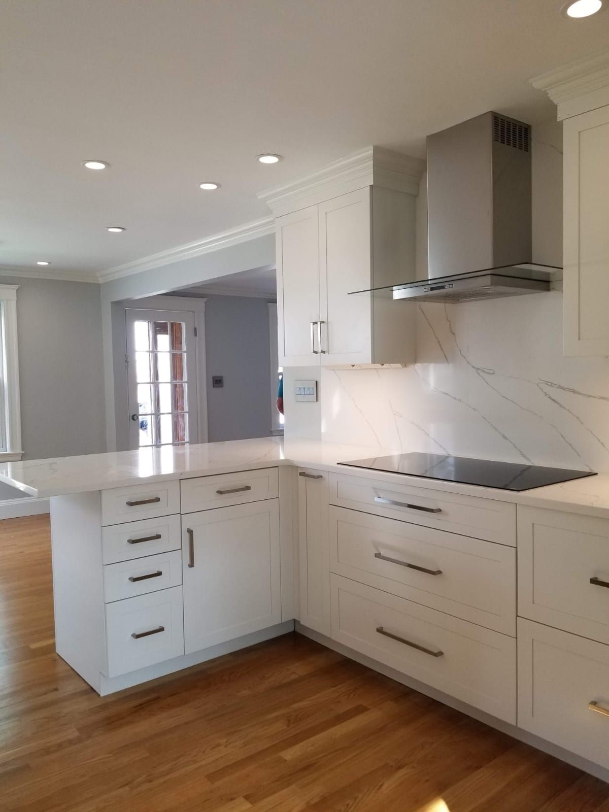 A kitchen with white cabinets and a stove top oven.