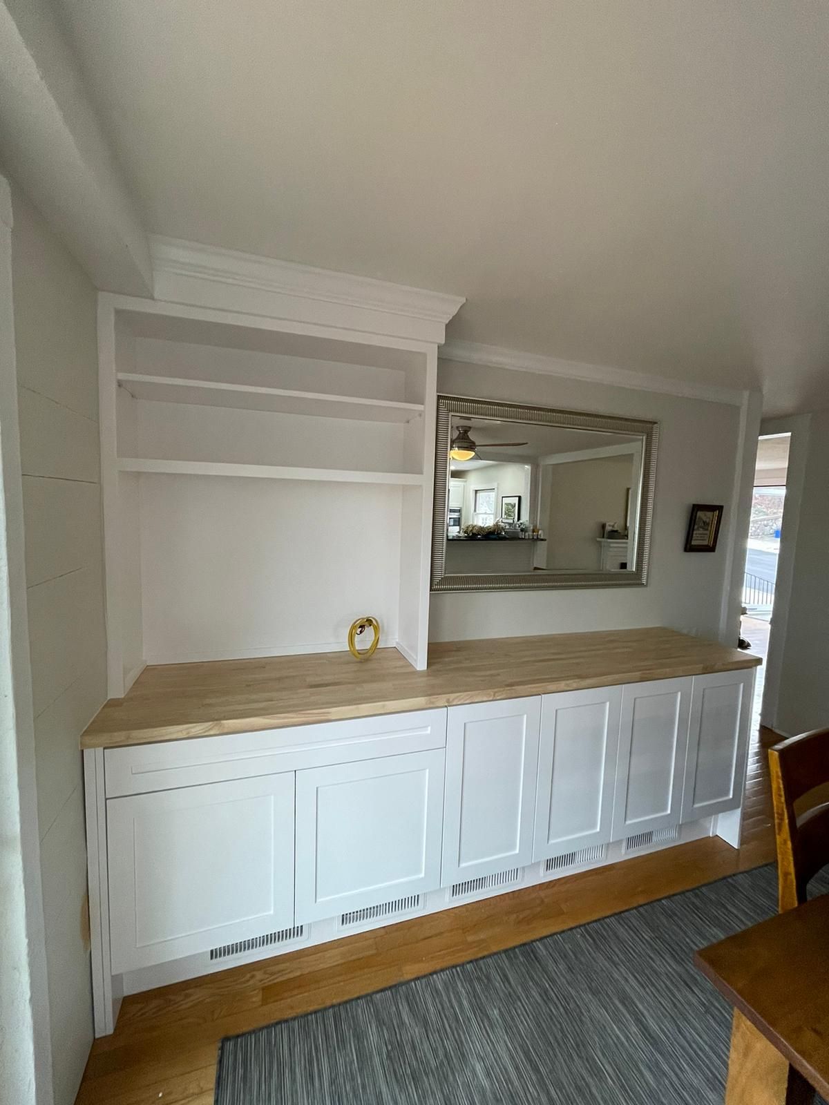 A living room with white cabinets and a wooden counter top.