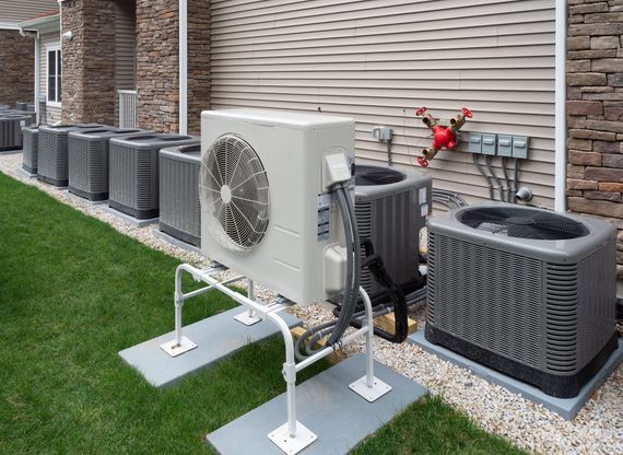Air conditioning units on grass next to a building.