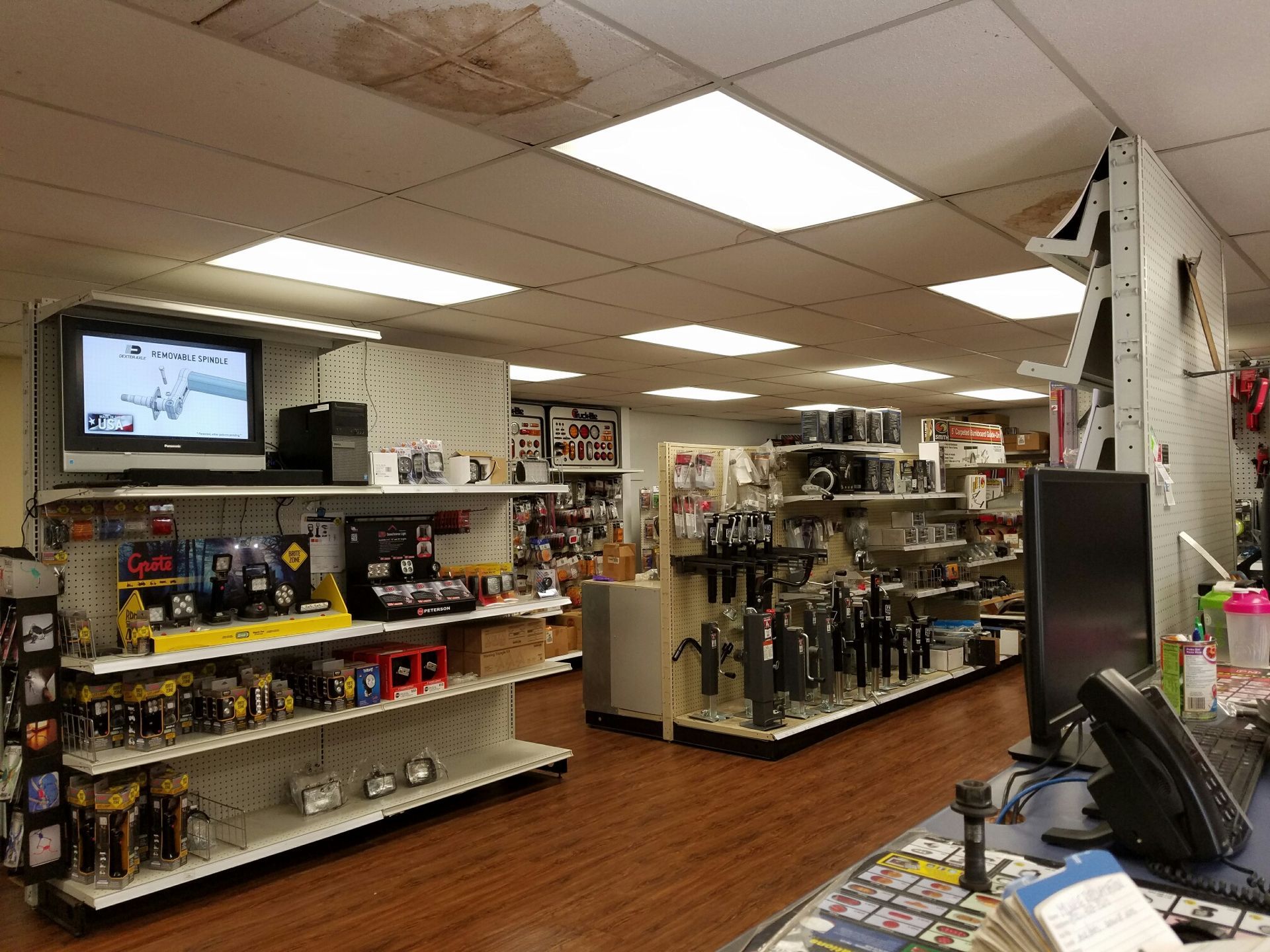 A store with lots of shelves and a tv on the wall