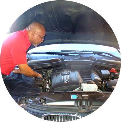 A repairman checking on the engine of a car