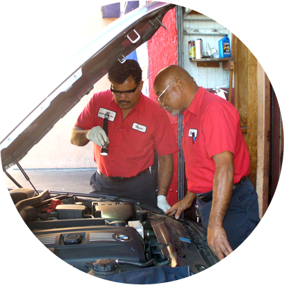 Two men checking some parts of an auto