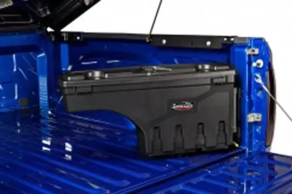 Black truck bed toolbox installed in a blue truck bed.