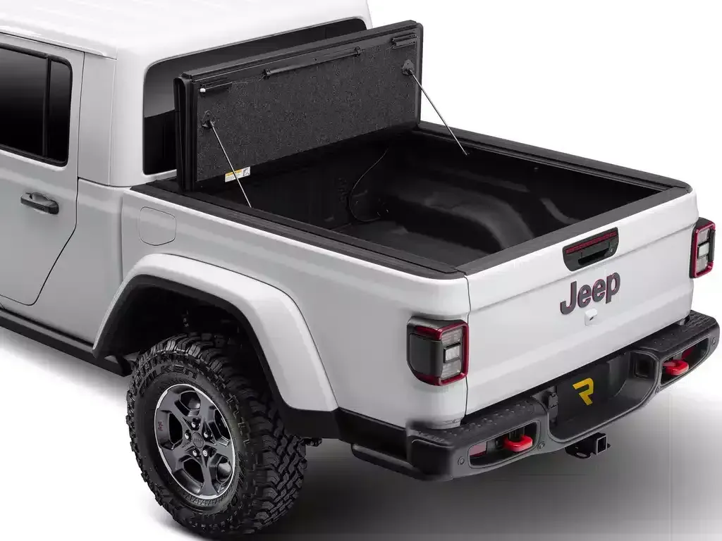 White Jeep Gladiator truck with open black tonneau cover.