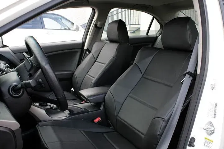 Black leather car seats in a white vehicle interior.