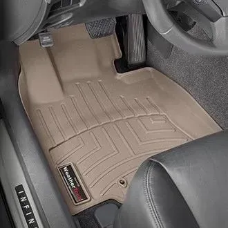 Tan car floor mat in a vehicle interior, protects the driver's side footwell.