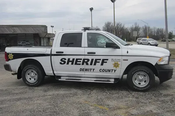 White DeWitt County Sheriff's truck parked outside a building on a cloudy day.