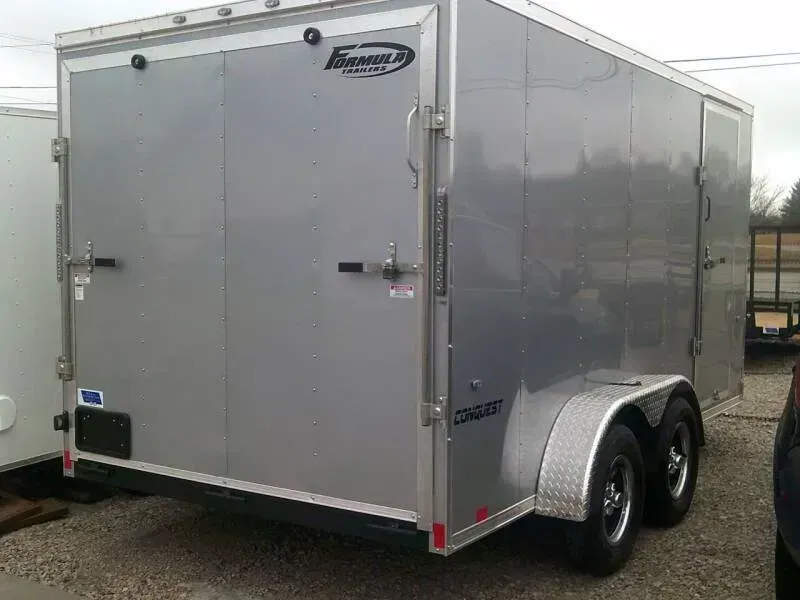 Silver enclosed cargo trailer with two rear doors and two wheels.