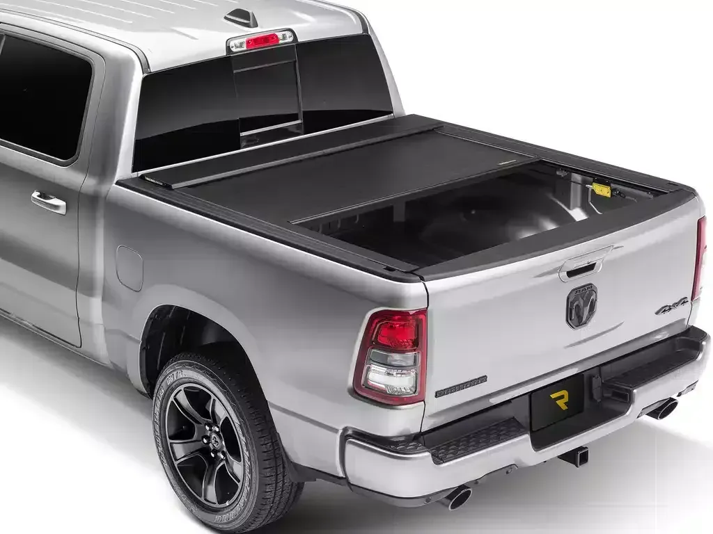 Silver pickup truck with black bed cover.