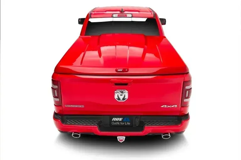 Red Ram pickup truck with a closed bed cover, viewed from the rear.