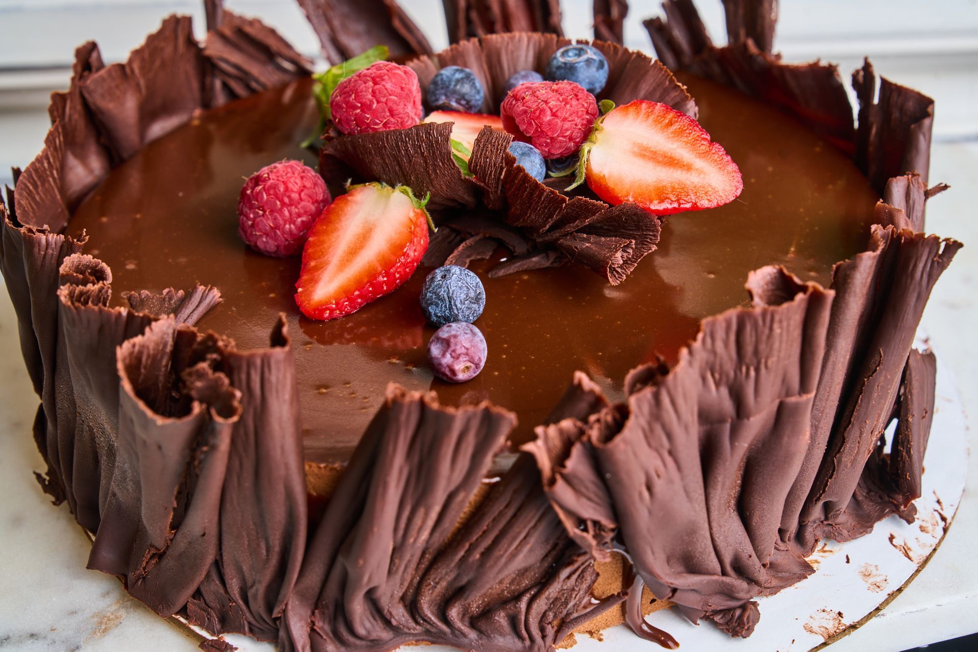 Chocolate cake with chocolate curls and fresh berries.