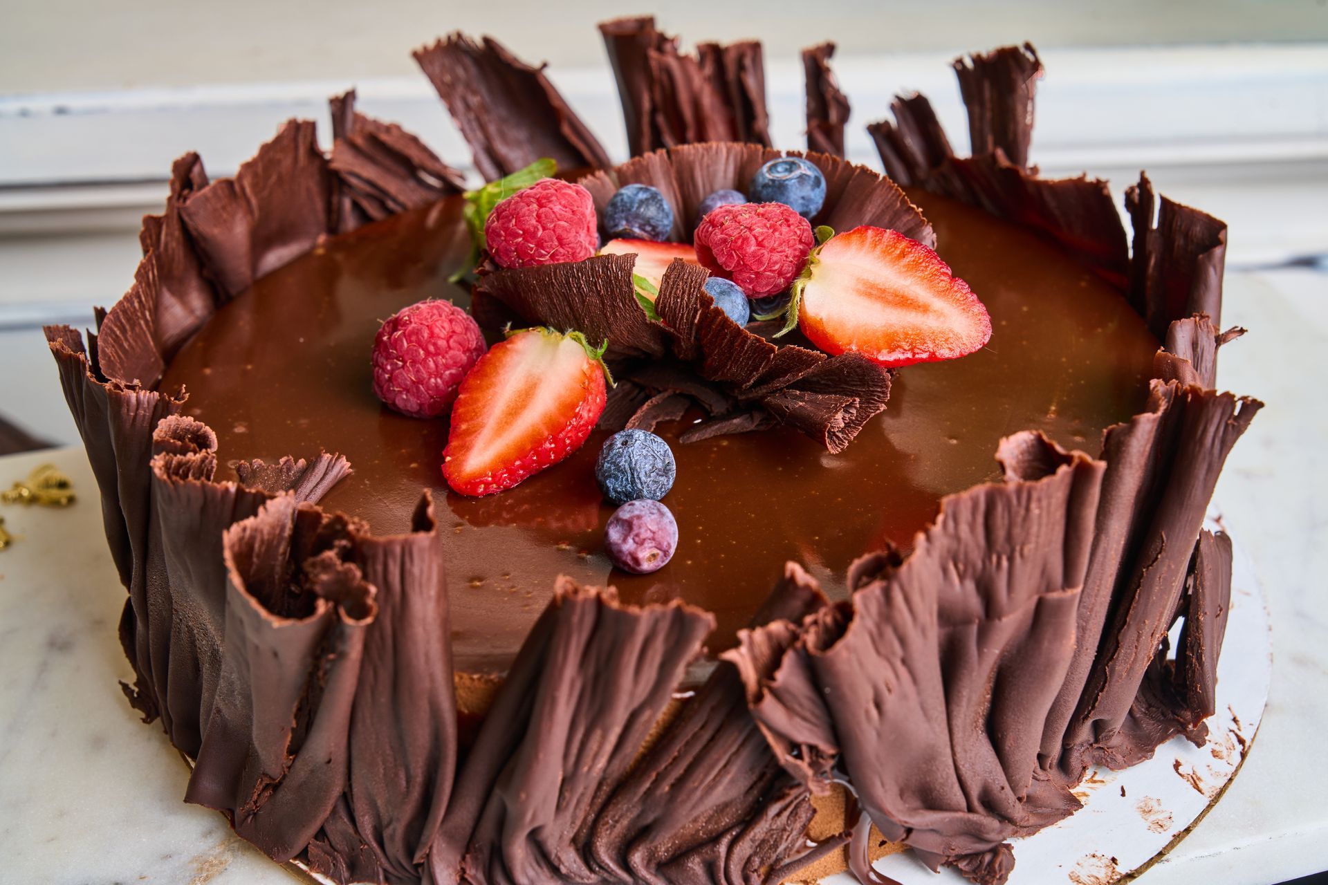 Chocolate cake with chocolate curls and fresh berries.