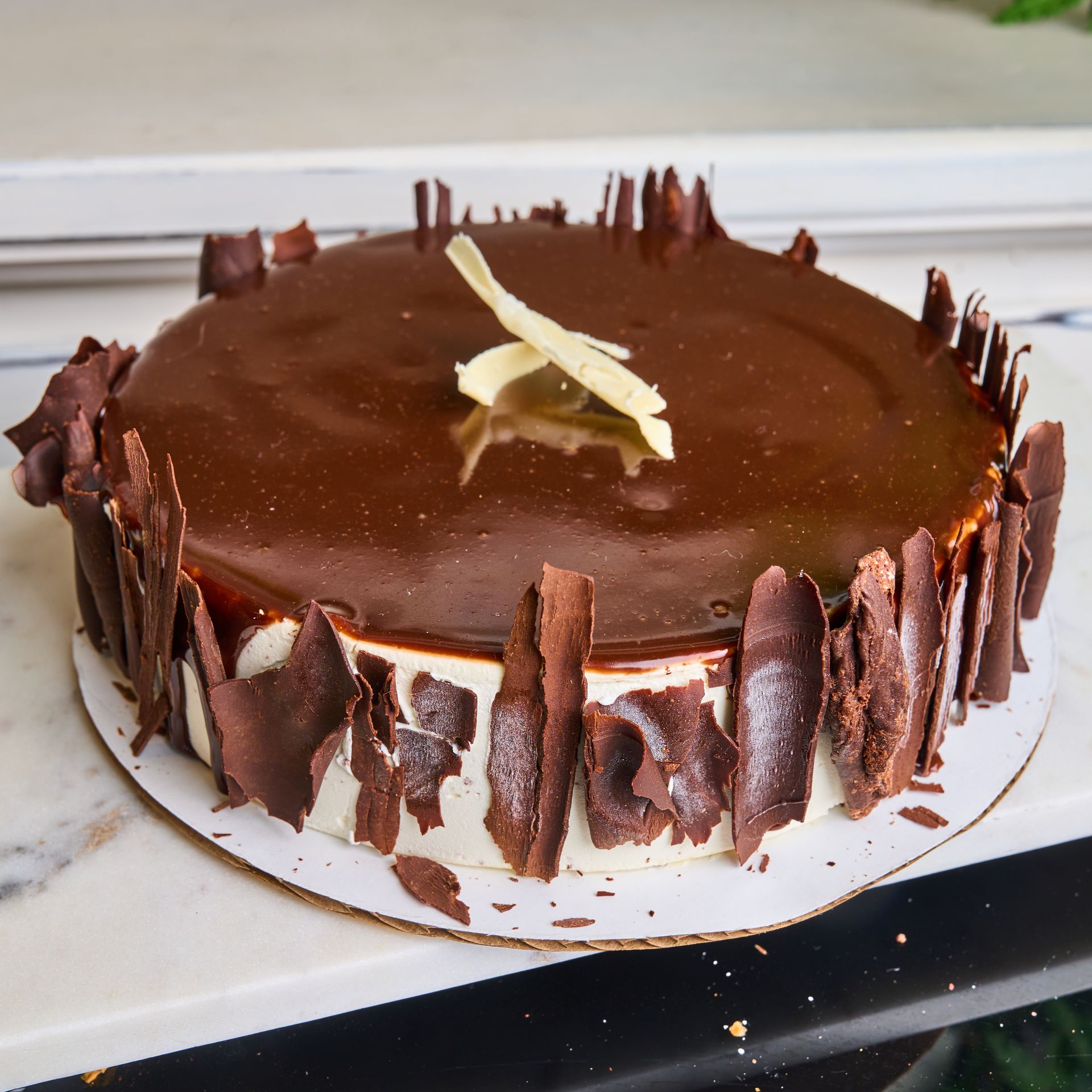 Chocolate cake with ganache frosting and chocolate shard decorations.
