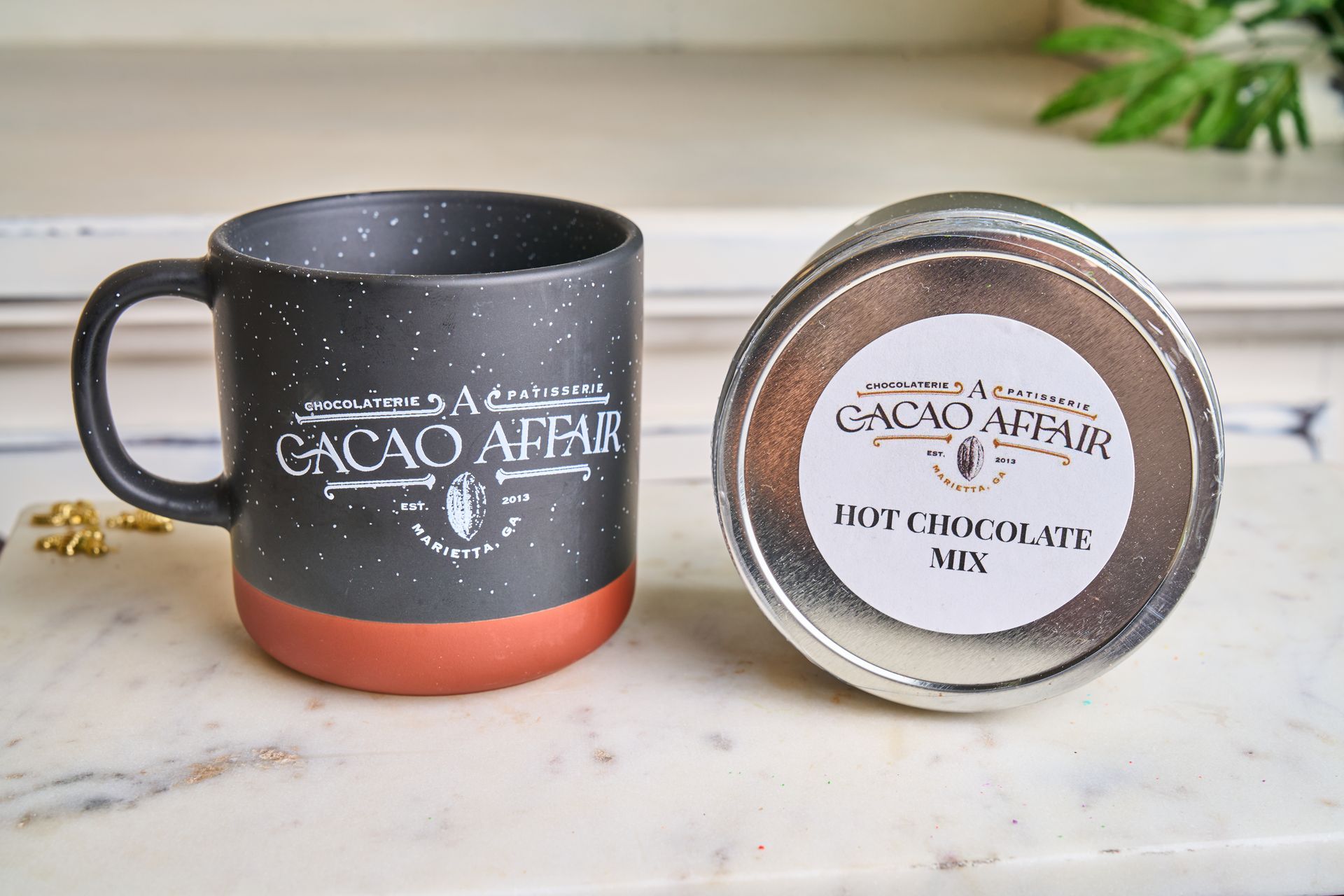Mug and hot chocolate mix tin. Dark speckled mug, terracotta base, 